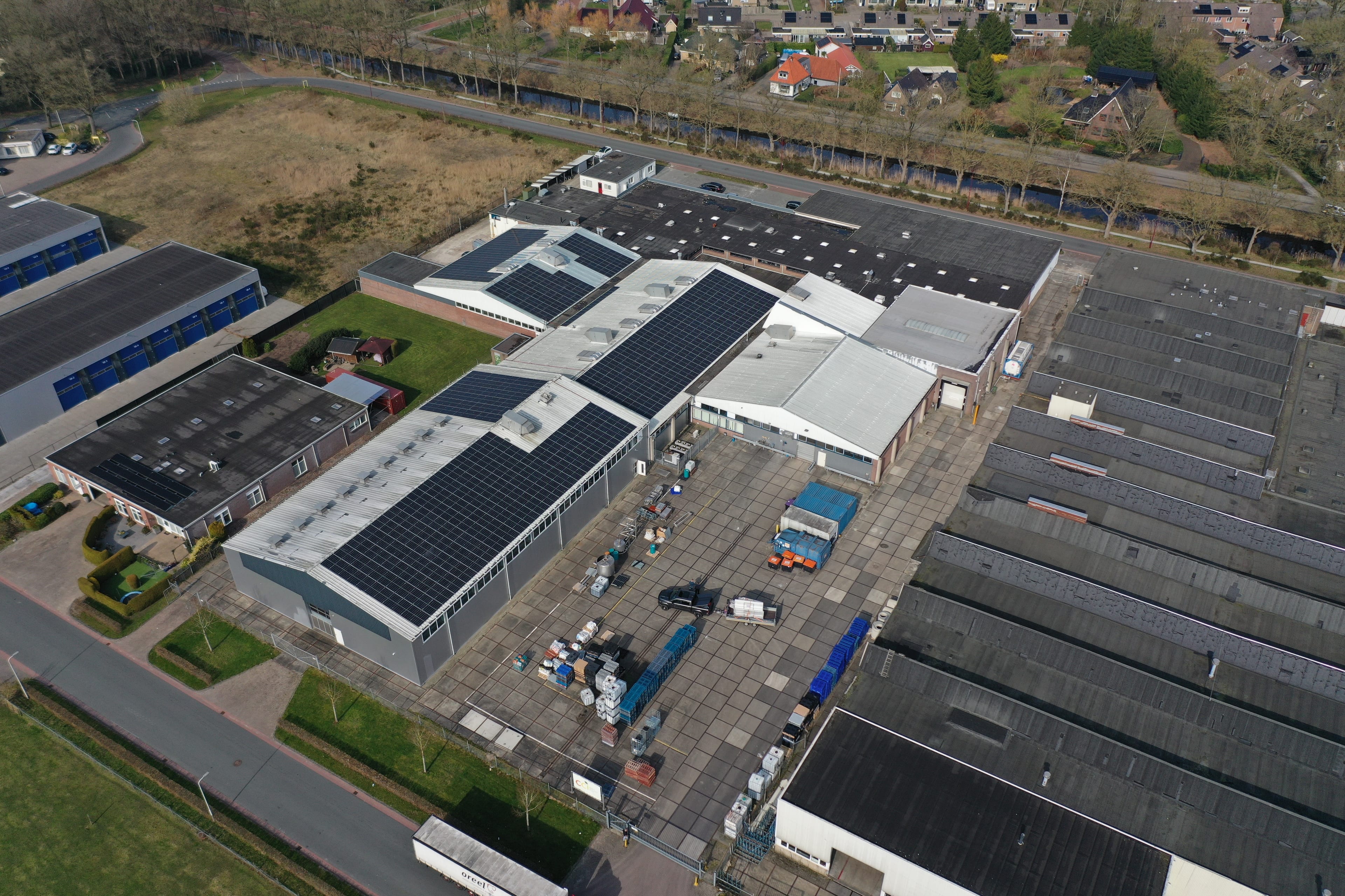 Luchtfoto van een bedrijfscomplex met zonnepanelen op de daken — een gerealiseerd Energie Totaal-project